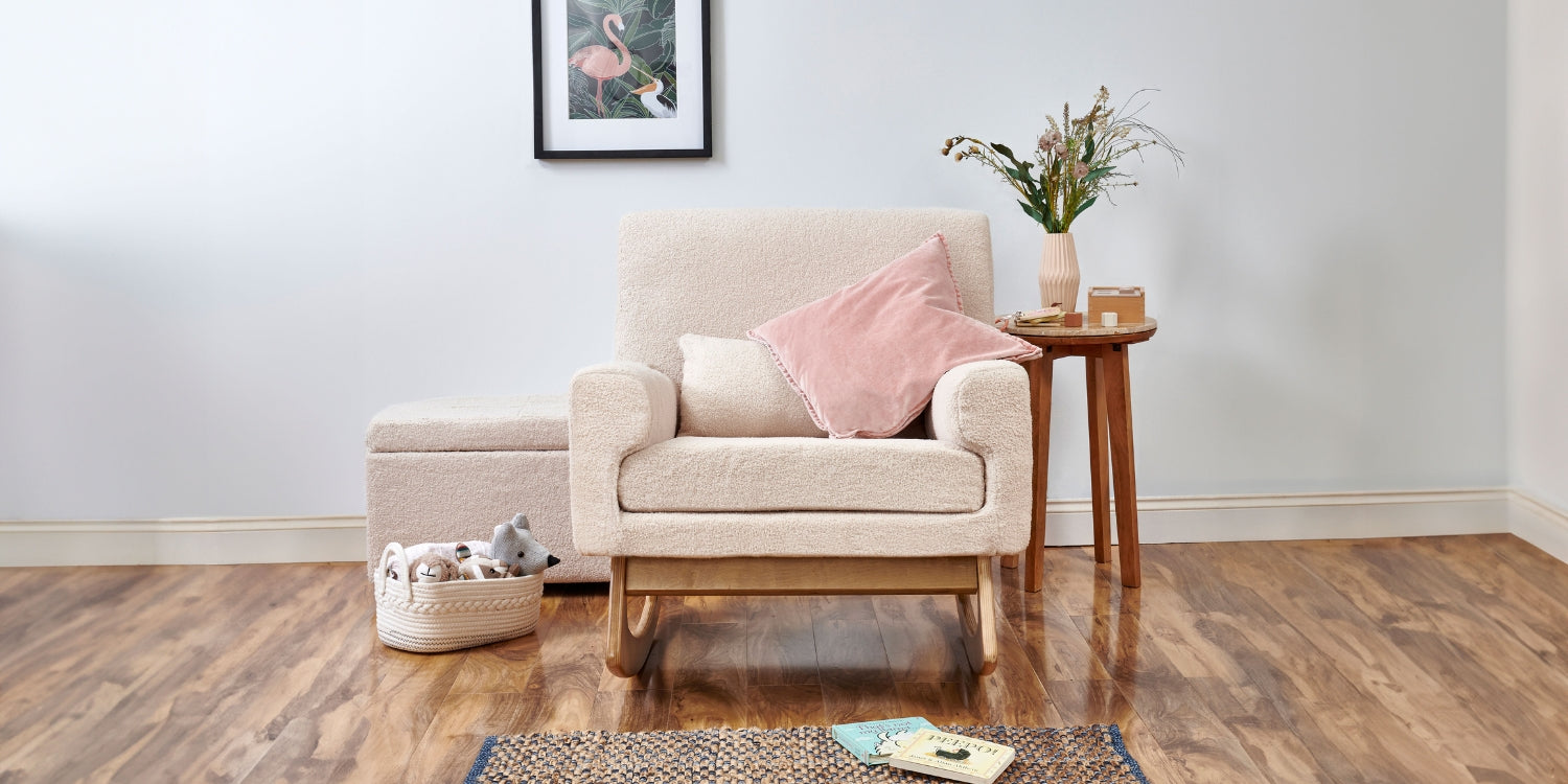 The Serena Rocking and Nursing Chair in Biscuit Boucle with a velvet pink cushion placed on the seat and the footstool in the background