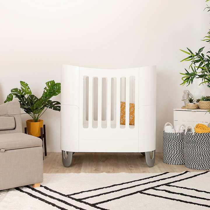 Serena Cot Bed and Mini Cot in all white made from sustainably souced FSC wood with baby safe and toxin free paint with recycled aliminium feet
